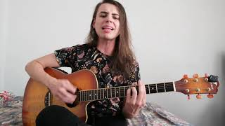 musico está no centro com uma camiseta com flores tocando violão.