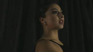 bailarina aparece ao centro. a imagem mostra seus ombros e cabeça com o traje comum ao ballet.