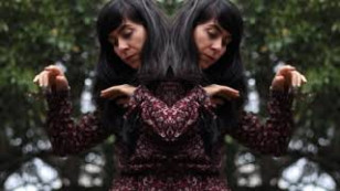 Artista ao centro duplicada com arvores ao fundo