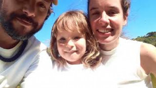 um homem e uma mulher dividem o plano com uma criança ao centro