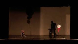 palco de teatro com uma pessoa a esquerda, sua sombra divide o plano, a direita